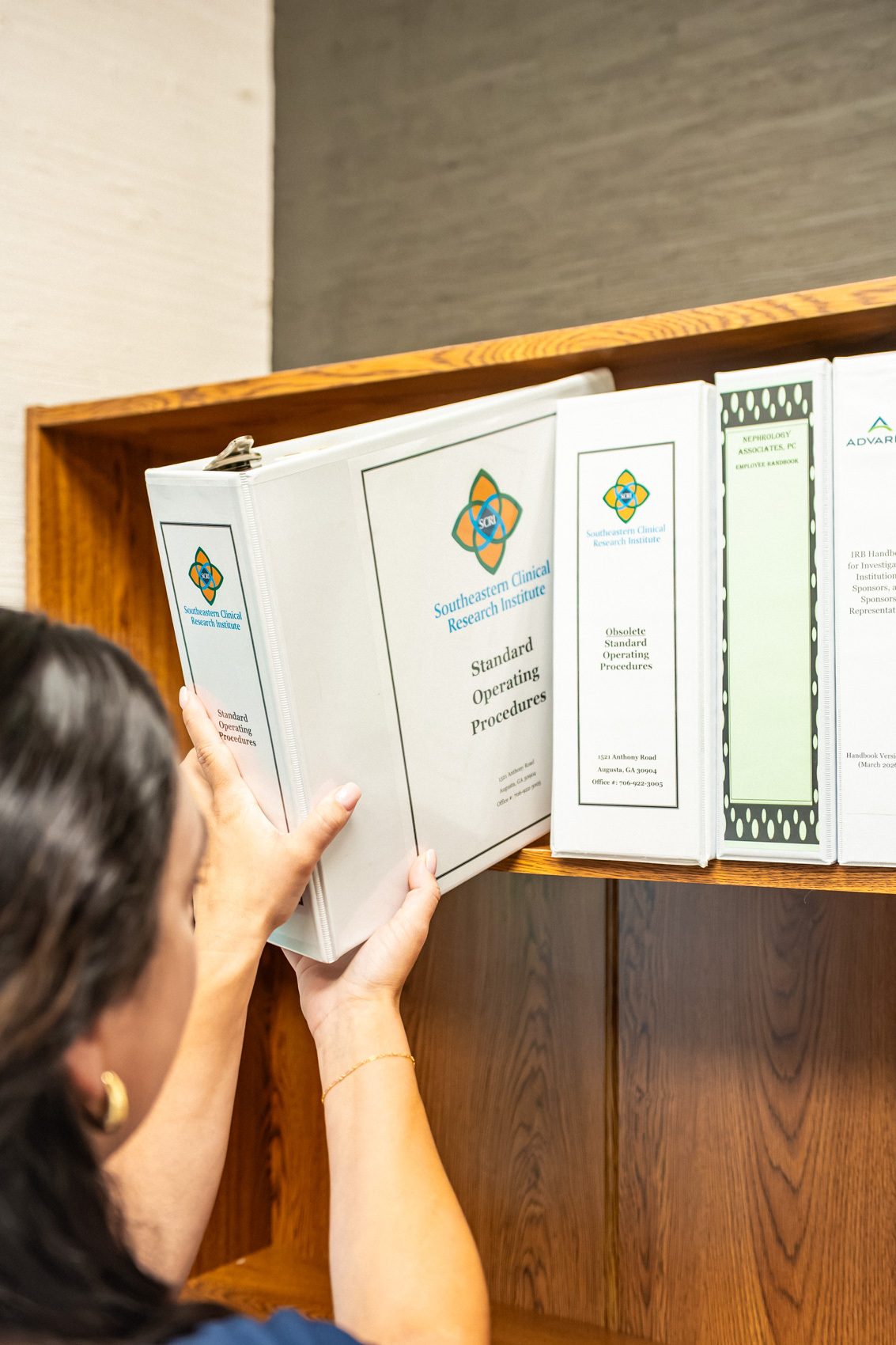 A research coordinator pulling regulatory binders